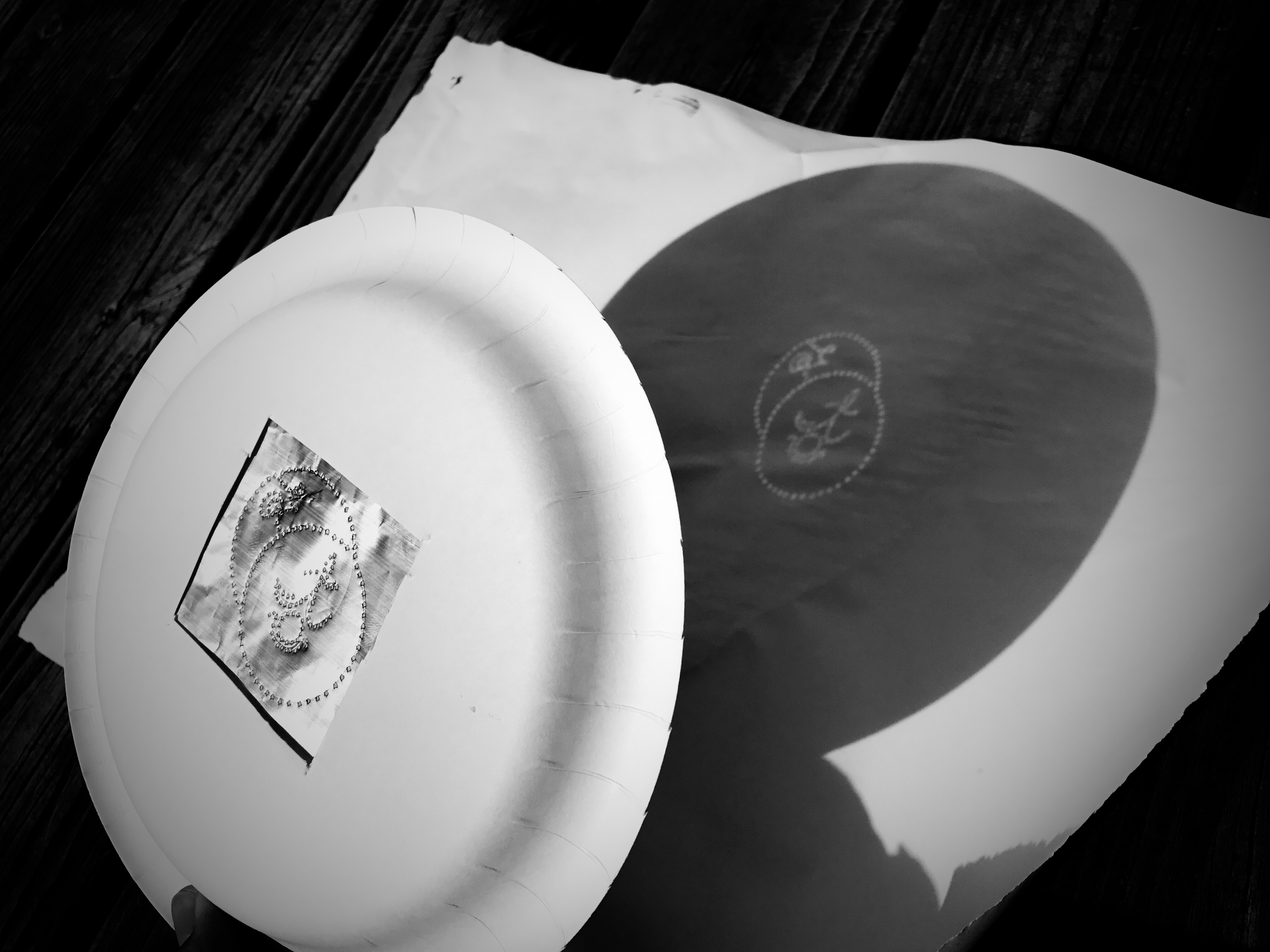 the sigil punched into a paper plate held out in the sun and projecting the image onto a piece of paper