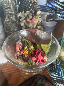 glass bowl full of flower, grain, and other offerings